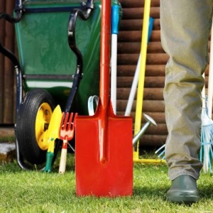 Leg of a Man Standing with a Shovel in a Yard --- Image by © Royalty-Free/Corbis